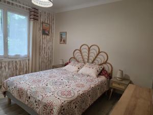 a bedroom with a bed with a red and white comforter at La Grillotte in Vieux-Boucau-les-Bains