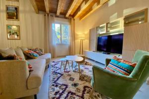 a living room with a couch and a tv at Holiday Home nature and swimming pool in Provence ! in Mérindol