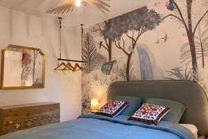 a bedroom with a bed with a mural of trees and birds at Holiday Home nature and swimming pool in Provence ! in Mérindol