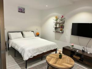 a bedroom with a bed and a flat screen tv at The Lennox D-Plus Apartments in Accra +75 photos