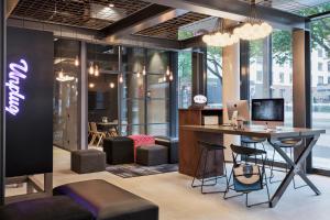 an office with a desk with a computer and chairs at MOXY Frankfurt East in Frankfurt