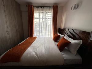 a bedroom with a large bed with a window at Joto House in Muchatha