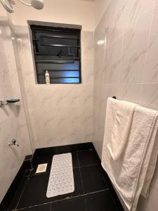 a bathroom with a toilet and a window and a towel at Joto House in Muchatha