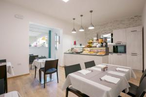 a dining room with two tables and a kitchen at Admayora Guest House in Villasimius