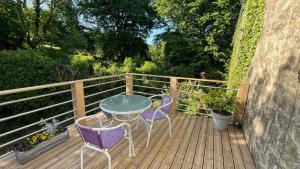 a table and two chairs on a wooden deck at Chambre d hôtes le 23 in Ségrie-Fontaine