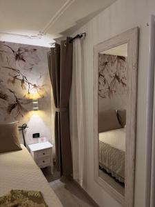 a bedroom with two beds and a mirror at Palazzo Carignano in Chioggia