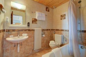 a bathroom with a sink and a toilet and a shower at Hotel Relais Alpin in Les Mosses +158 photos