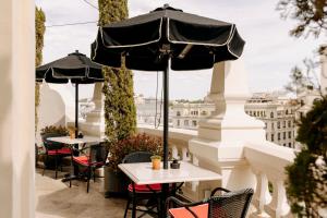 a patio with tables and umbrellas on a balcony at The Principal Madrid, Small Luxury Hotels in Madrid