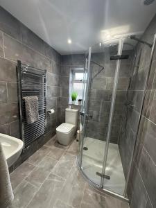a bathroom with a shower and a toilet and a sink at Modern homely well equipped 2BR bungalow next to the racecourse free parking in Hereford +27 photos