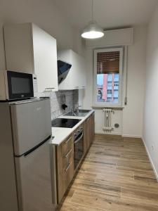 a kitchen with a refrigerator and a sink at Maison Regina in Vigevano +8 photos