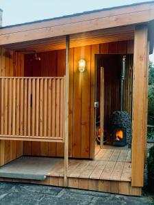a wooden house with a fireplace in front of it at Peartree Cottage in Sandhoe