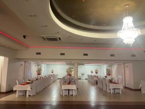 a banquet hall with white tables and white chairs at Hotel Arkadia in Końskie