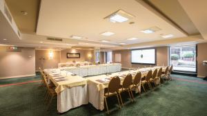 ein Konferenzraum mit Tischen, Stühlen und einer Leinwand in der Unterkunft Hyllit Hotel in Antwerpen + 73 Fotos