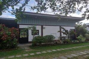 a white house with a door and a yard at Seven Waves Beachfront Residence - La Union in Bagbag Oeste