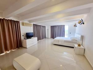 a large white bedroom with a bed and a tv at Le Domaine paradise in Briska Gora