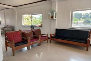 a living room with two benches and two windows at Seven Waves Beachfront Residence - La Union in Bagbag Oeste