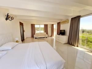 a bedroom with a white bed and a large window at Le Domaine paradise in Briska Gora +55 photos