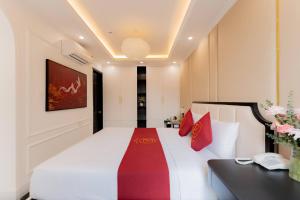 a hotel room with a bed and a desk at Bailey Hotel Hue in Hue