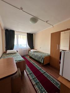 a hotel room with two beds and a table at Samal Resort and SPA in Taraz +55 photos