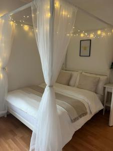 a white bed with a canopy with lights on it at The Cotton Mill Hideaway - One Bedroom Apartment - Free Parking near Etihad Stadium & CoOp Live in Manchester