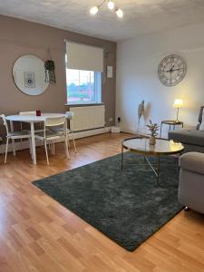 a living room with a table and a couch at The Cotton Mill Hideaway - One Bedroom Apartment - Free Parking near Etihad Stadium & CoOp Live in Manchester