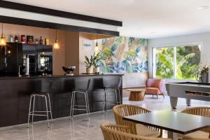 a restaurant with a bar with chairs and tables at AluaSun Costa Park in Torremolinos