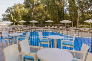 a row of tables and chairs next to a swimming pool at AluaSun Costa Park in Torremolinos