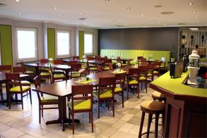 a restaurant with tables and chairs in a room at Hotel Heidenschanze in Dresden