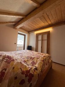 a bedroom with a bed in a room with a window at Baita dal Bigolaro in Vetriola +3 photos