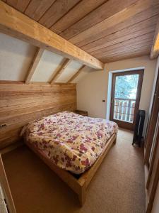 a bed in a room with a wooden ceiling at Baita dal Bigolaro in Vetriola
