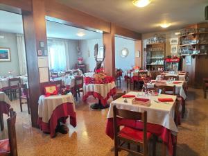 a restaurant with tables with red and white tablecloths at Hotel Monte Fior in Foza +34 photos