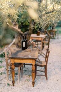 a wooden table with two bottles and a glass of wine at Opora Country Living in Nafplio