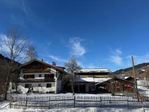 a house with a fence in the snow at Heulandhof in Bad Hindelang