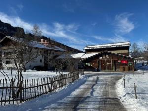 a barn in the snow with a fence at Heulandhof in Bad Hindelang