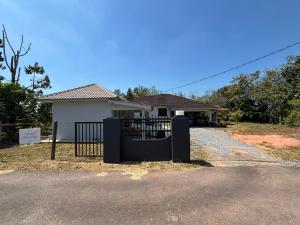 a house with a black gate in front of it at Cahaya roomstay in Kangar