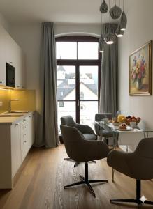 a kitchen and dining room with a table and chairs at Karmeliterhof Studios & Suites in Boppard