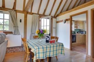 a dining room with a table with a vase of flowers on it at 1 Bed in Tenterden oc-tn621 in Tenterden +11 photos