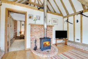 a living room with a brick fireplace and a tv at 1 Bed in Tenterden oc-tn621 in Tenterden