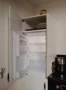 an empty refrigerator with its door open in a kitchen at Huis Elsje in Emst +68 photos