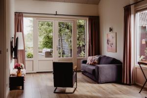 a living room with a couch and a sliding glass door at Huis Elsje in Emst