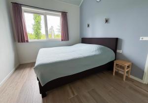 a small bedroom with a bed and a window at Huis Elsje in Emst