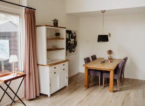 a kitchen and dining room with a wooden table at Huis Elsje in Emst