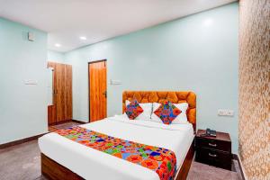 a bedroom with a large white bed with colorful sheets at Via Emara Inn - Lalbagh Botanical Garden in Bangalore