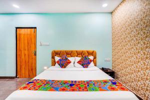 a bedroom with a large bed with a colorful comforter at Via Emara Inn - Lalbagh Botanical Garden in Bangalore