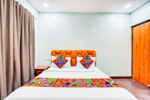 a bedroom with a large bed with colorful pillows at Via Emara Inn - Lalbagh Botanical Garden in Bangalore +22 photos