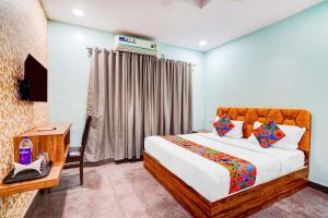 a bedroom with a bed and a table and a television at Via Emara Inn - Lalbagh Botanical Garden in Bangalore