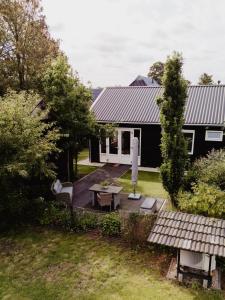 a backyard of a black house with a table and chairs at Huis Elsje in Emst