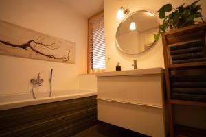 a bathroom with a tub and a sink and a mirror at An der Kirchtreppe in Blankenburg +33 photos