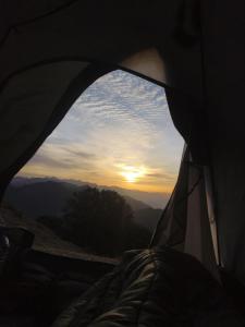 a view of the sunset from inside of a tent at Himalayan Cloud Door Camps in Dehradun +8 photos