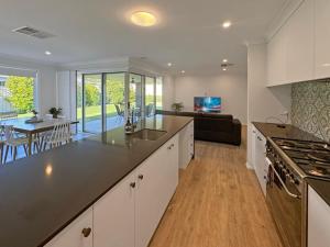 a kitchen with a counter top and a living room at Paradise Stay in North Wagga